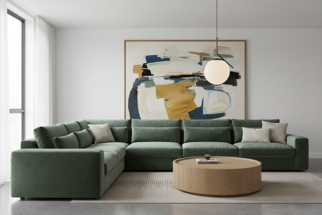 Living room with large sage green velvet sectional as centerpiece, oak coffee table, abstract artwork and pendant light — how to choose the right sofa for your living room