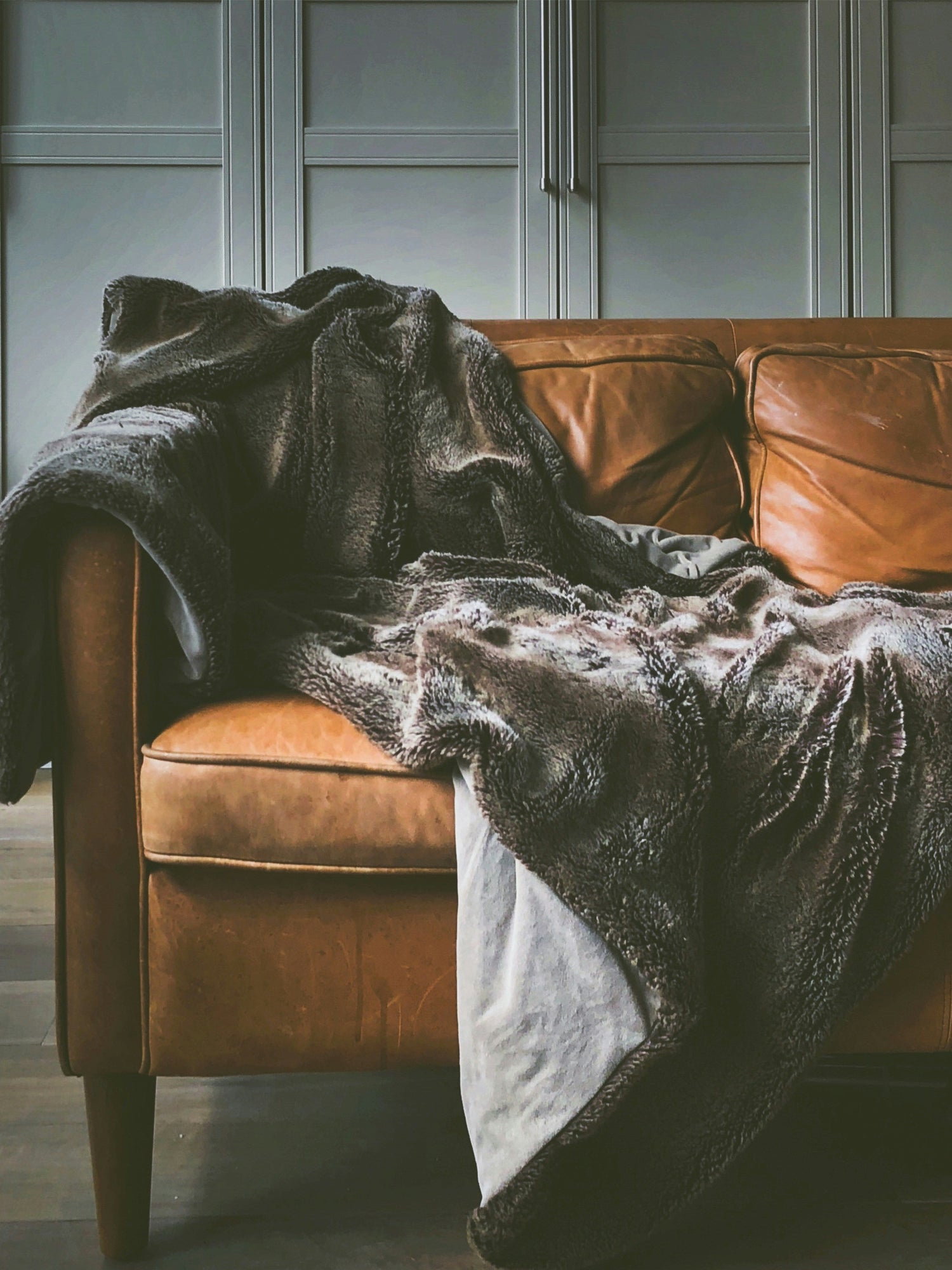Cozy blankets and throws draped over a comfortable sofa